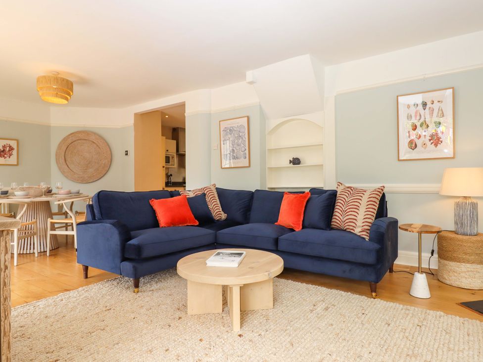 A living room with a blue sofa and a coffee table at The Porthole in Newton Ferrers