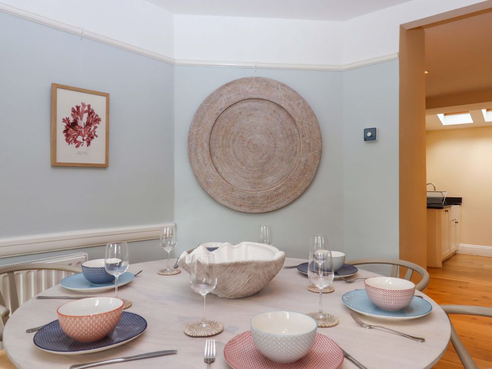 A dining room with a table set for meals at The Porthole in Newton Ferrers