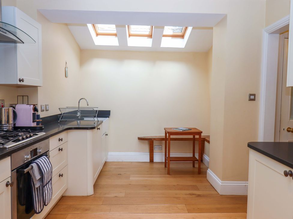 A kitchen with a cooking stove and table at The Porthole in Newton Ferrers