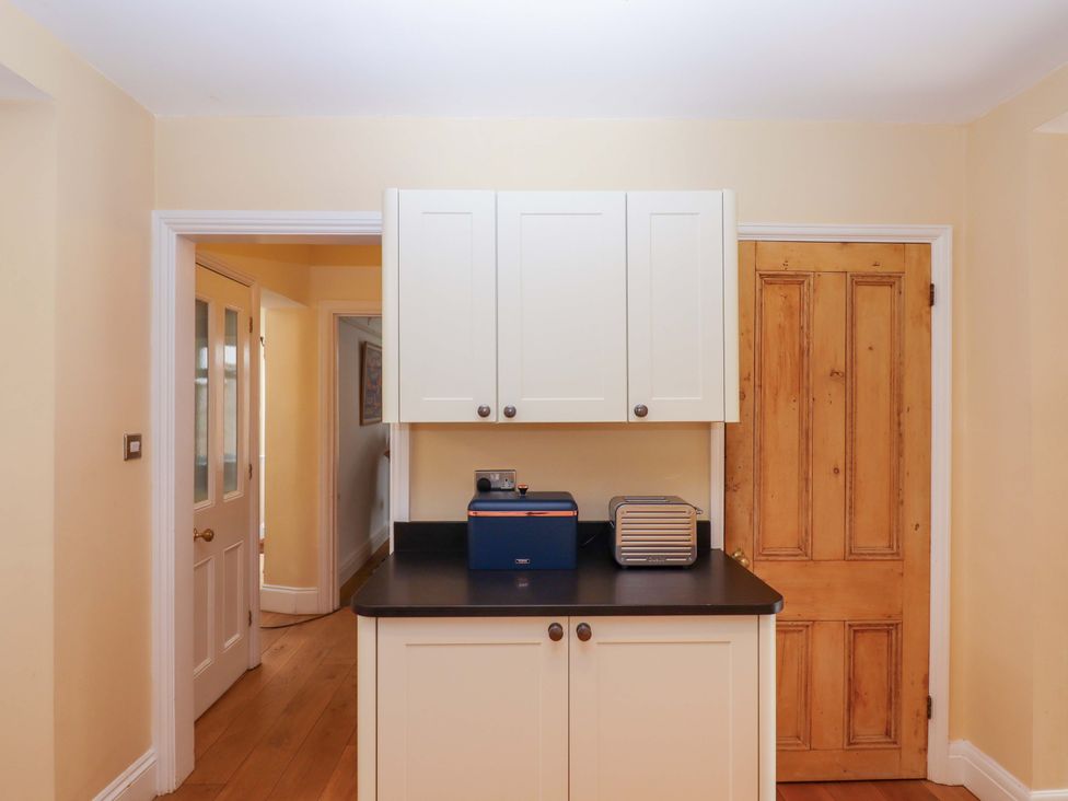 A kitchen with cupboards and appliances at The Porthole in Newton Ferrers