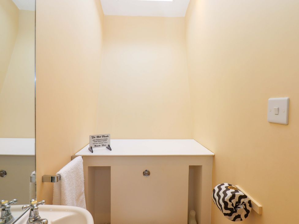 A bathroom with sink and mirror at The Porthole in Newton Ferrers