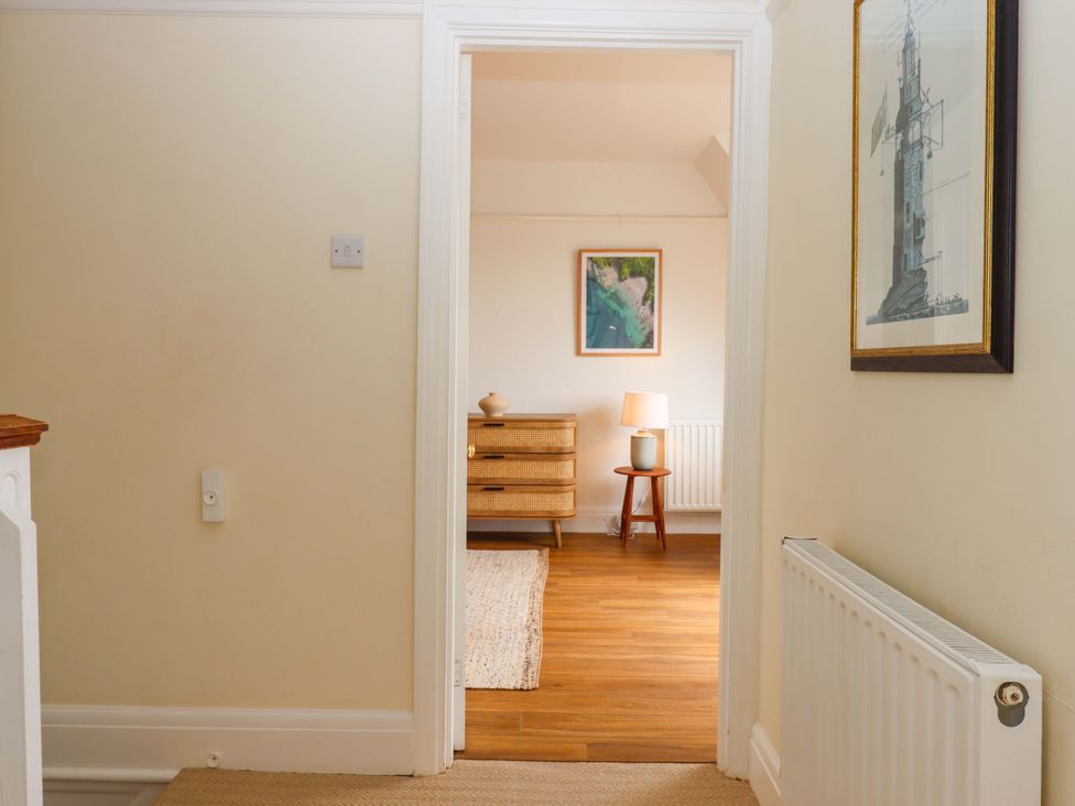 A hallway with a door leading to a room with furniture at The Porthole in Newton Ferrers