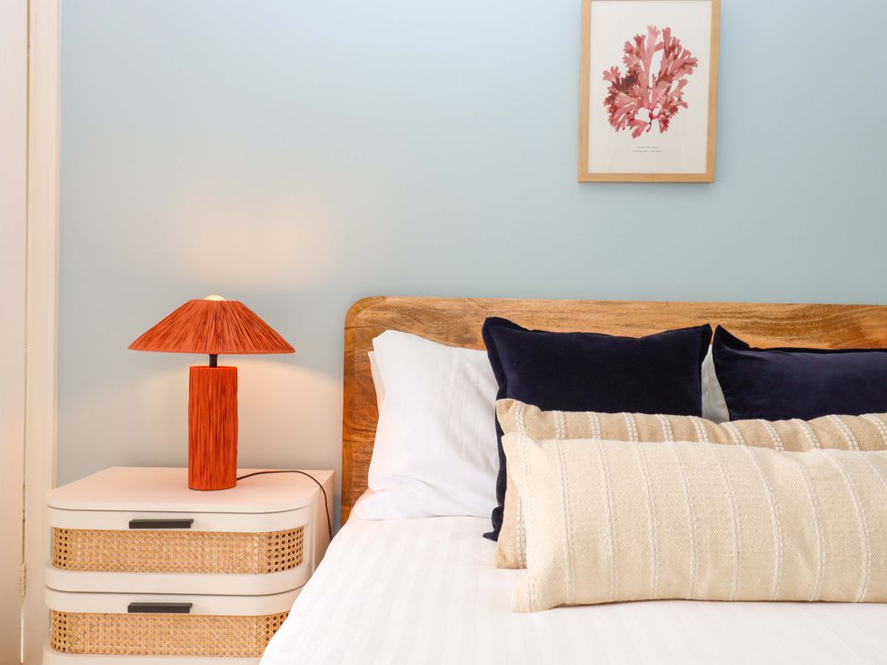A bedroom with a bed and bedside table at The Porthole in Newton Ferrers