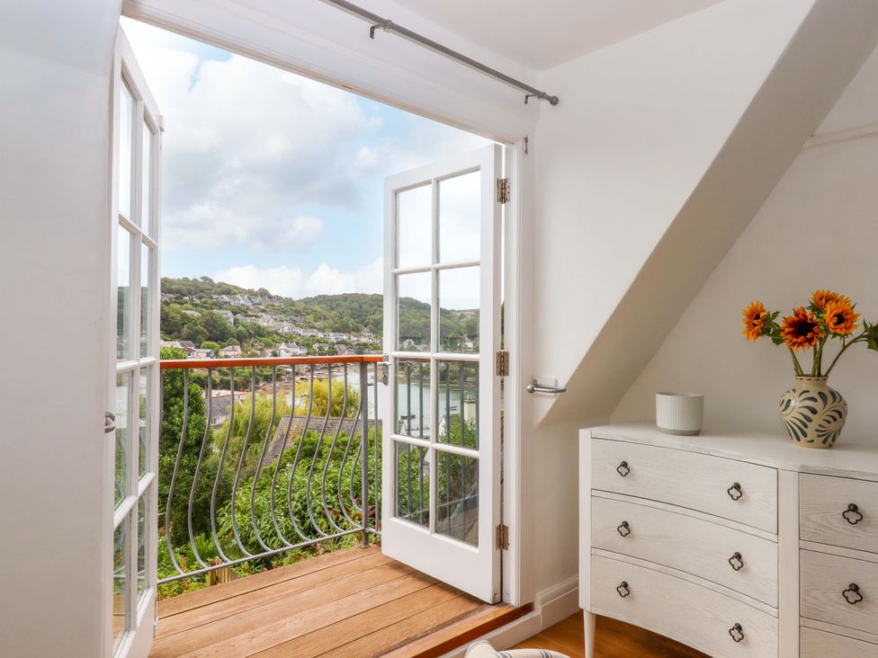 A room with double doors leading to a balcony at The Porthole in Newton Ferrers