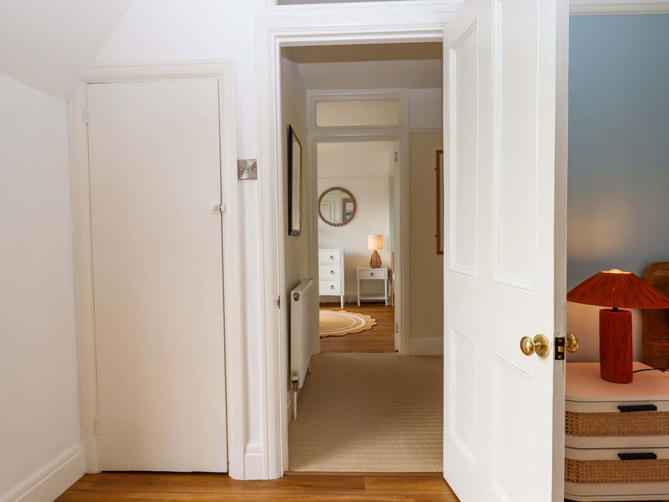 A hallway with a mirror and lamp at The Porthole in Newton Ferrers