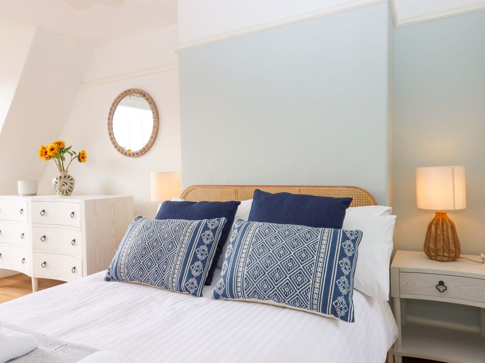 A bedroom with a bed and decorative pillows at The Porthole in Newton Ferrers