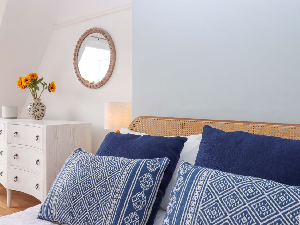 A bedroom with a bed and dresser at The Porthole in Newton Ferrers