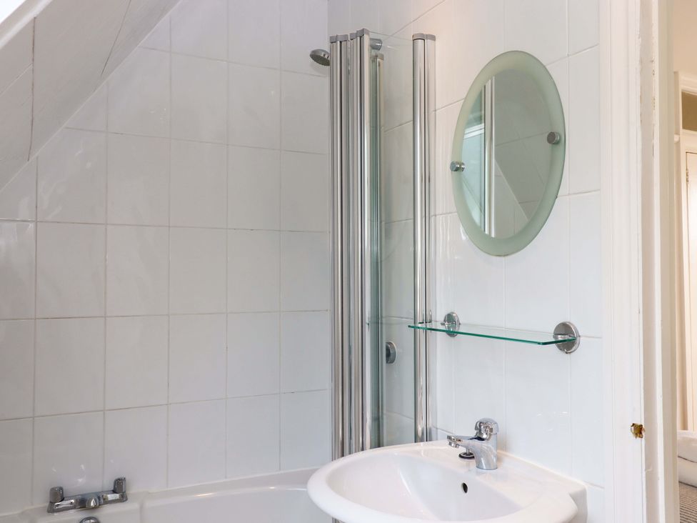 A bathroom with a shower and sink at The Porthole in Newton Ferrers