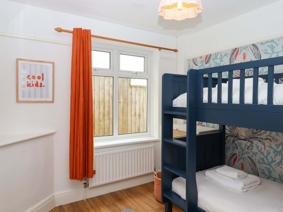 A bedroom with a bunk bed and a window at The Porthole in Newton Ferrers