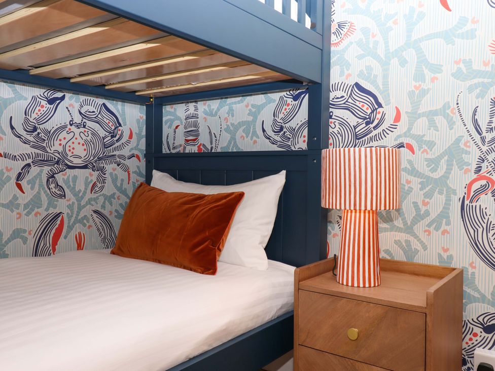 A bedroom with a bunk bed and lamp at The Porthole in Newton Ferrers