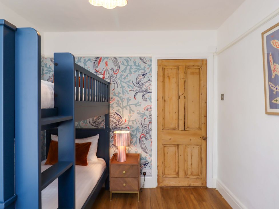A bedroom with a bunk bed and a nightstand at The Porthole in Newton Ferrers