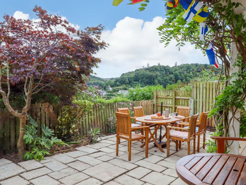 A garden with a table and chairs at The Porthole in Newton Ferrers