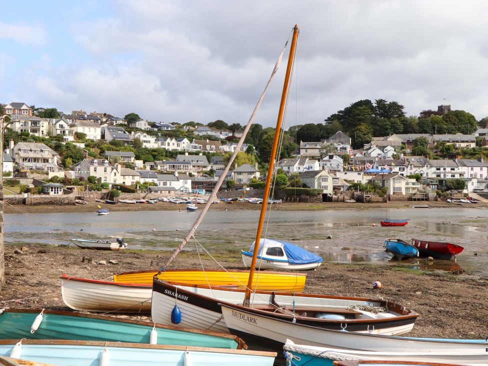 A view of boats on a shoreline with houses in the background at The Porthole in Newton Ferrers