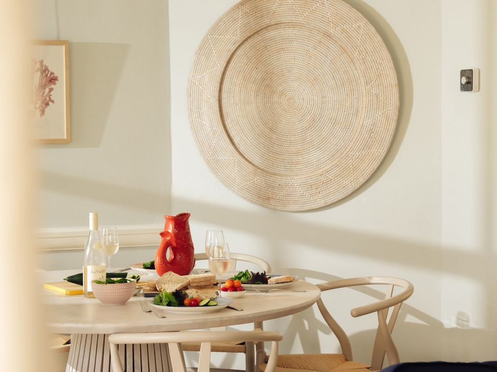 A dining room with a table set for a meal at The Porthole in Newton Ferrers