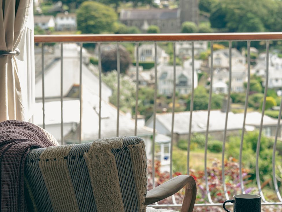 A balcony with a chair and a mug at The Porthole in Newton Ferrers
