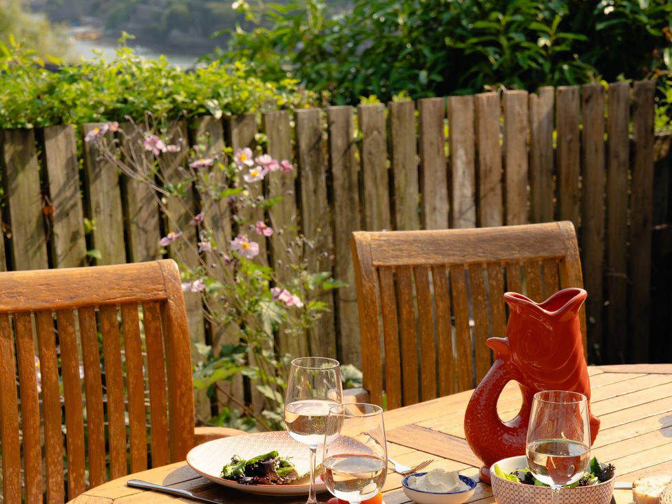 An outdoor dining area with a table set and a pitcher at The Porthole in Newton Ferrers