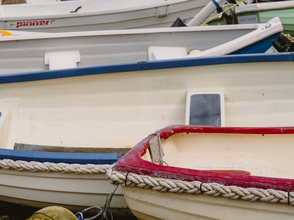 Various boats including red and blue boats in a harbor at The Porthole in Newton Ferrers