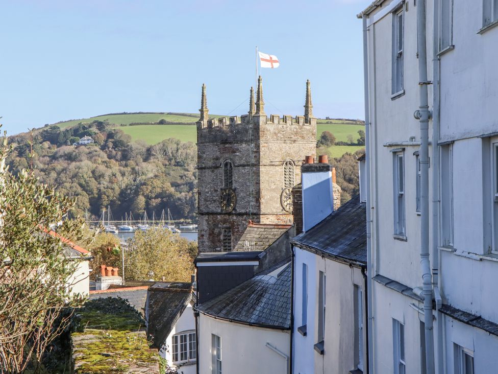 A view of a church tower with a flag and buildings at 26 Above Town in Dartmouth