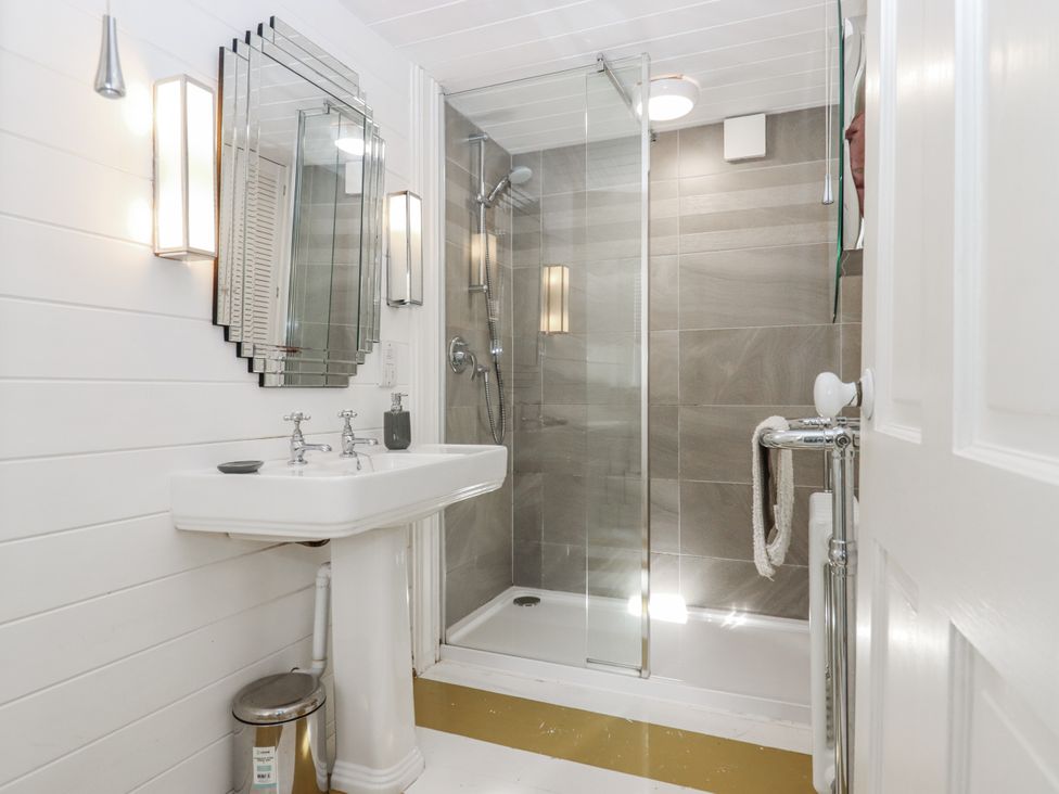 A bathroom featuring a sink, shower, and mirror at 26 Above Town in Dartmouth