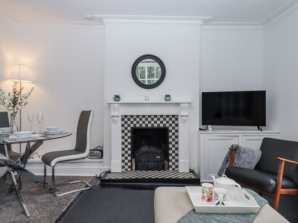 A living room with a fireplace and a dining area at 26 Above Town in Dartmouth