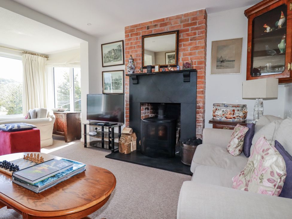 A living room with a fireplace and television at Kiln Cottage in Golant near Tywardreath