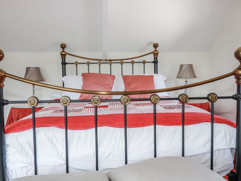 A bedroom with a bed and bedside lamps at Kiln Cottage in Golant near Tywardreath
