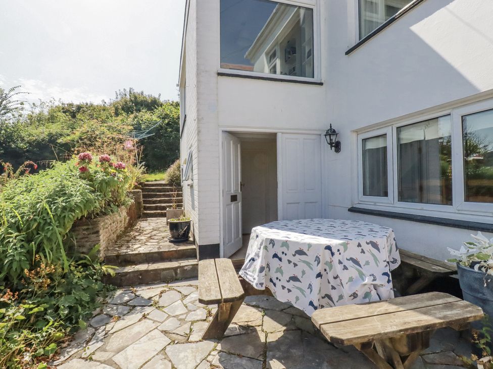 An outdoor area with a table and benches at Kiln Cottage in Golant near Tywardreath
