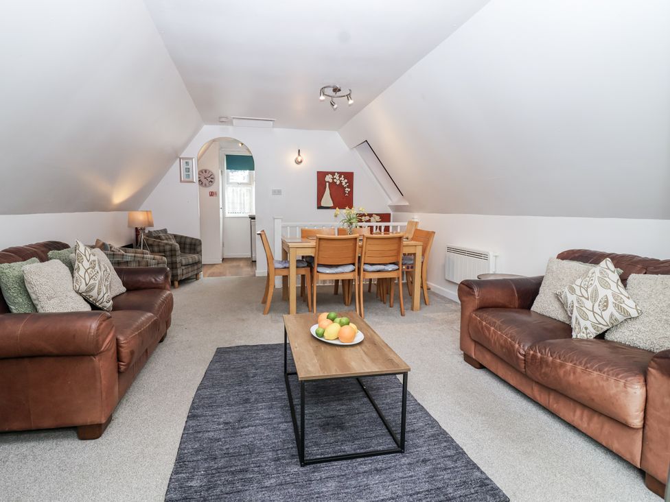 A living room with a sofa and dining area at Valley Lodge 20 in Callington