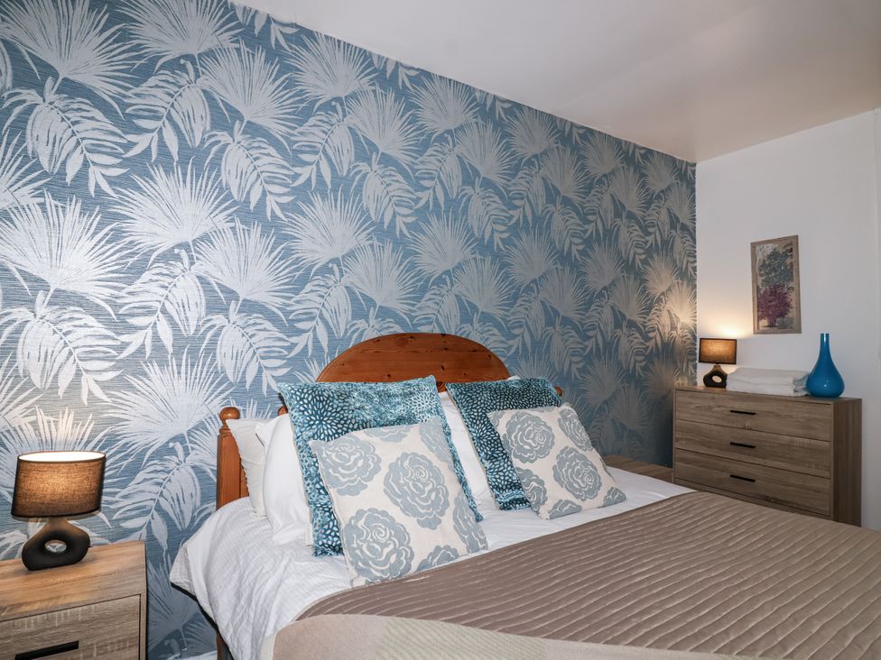 A bedroom with a bed and decorative pillows at Valley Lodge 20 in Callington