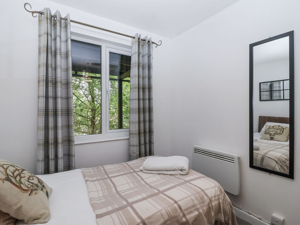 A bedroom with a bed and window at Valley Lodge 20 Callington