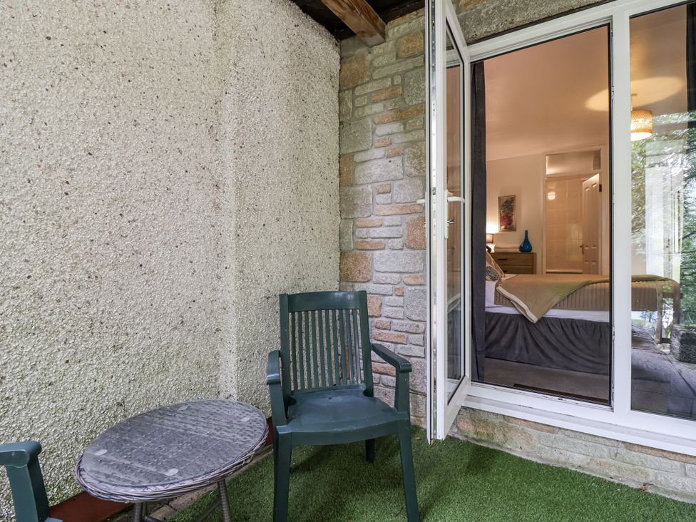An outdoor seating area with a table and chair at Valley Lodge 20 Callington