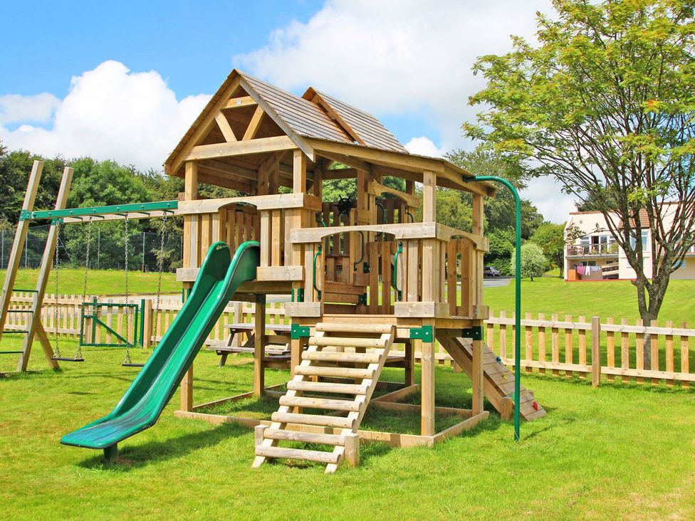 A playground structure with slide and swings at Valley Lodge 20 Callington
