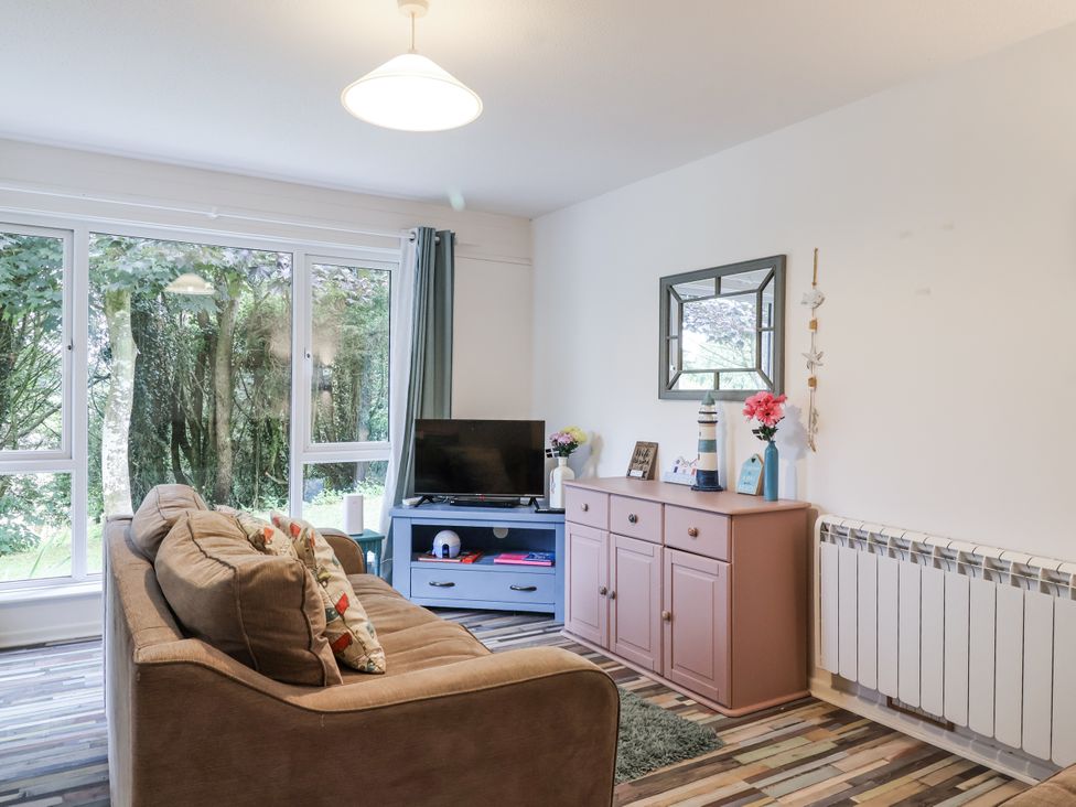 A living room with a sofa and television at Manorcombe 21 Honicombe Holiday Village near Gunnislake