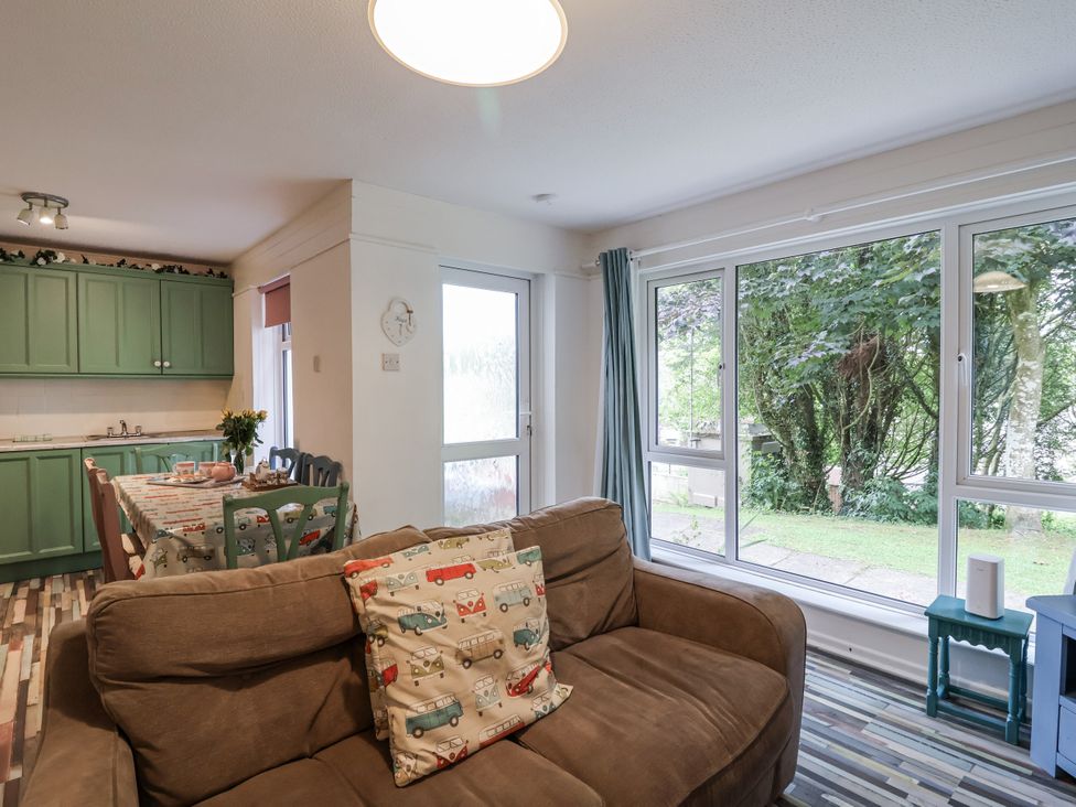 A living room with a sofa and kitchen area at Manorcombe 21 Honicombe Holiday Village near Gunnislake
