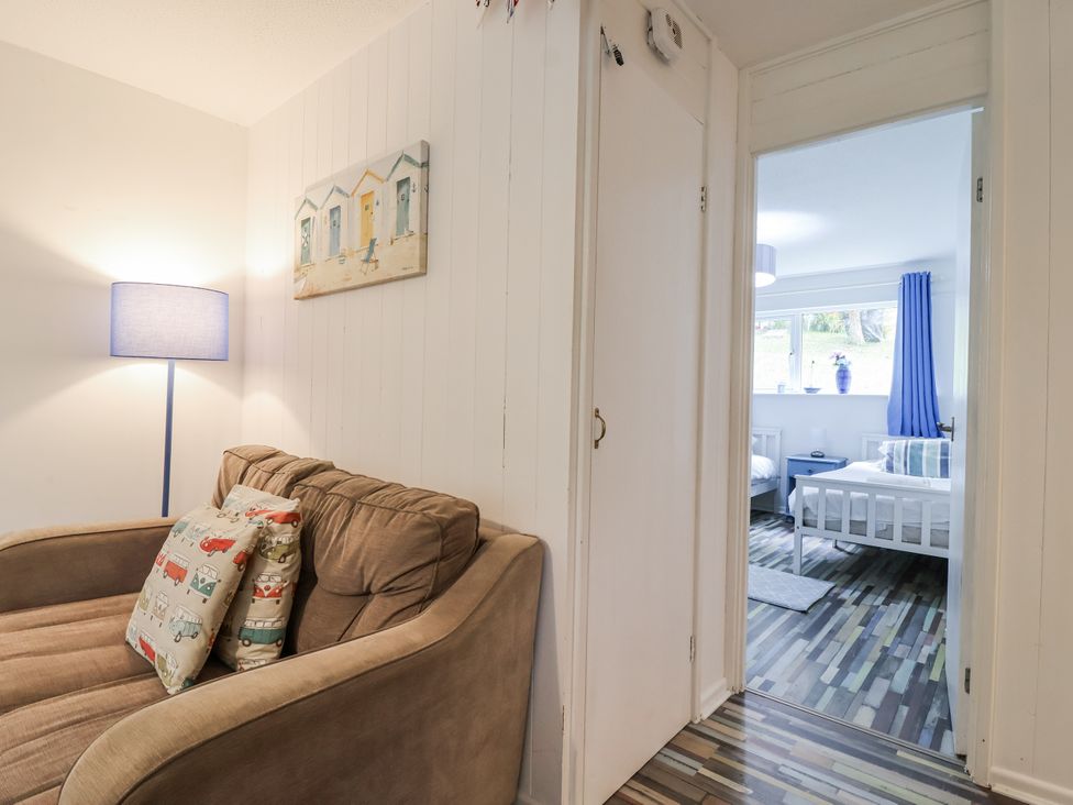 A living room with a sofa and door leading to a bedroom at Manorcombe 21 Honicombe Holiday Village near Gunnislake