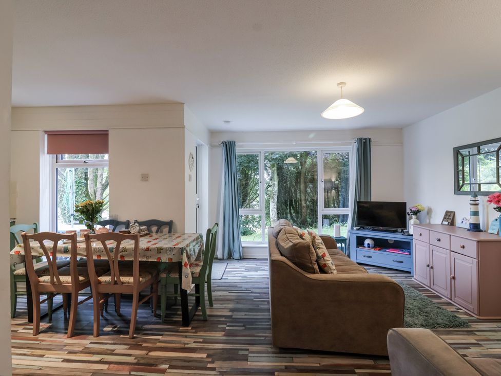 A living room with a dining area and windows at Manorcombe 21 Honicombe Holiday Village near Gunnislake