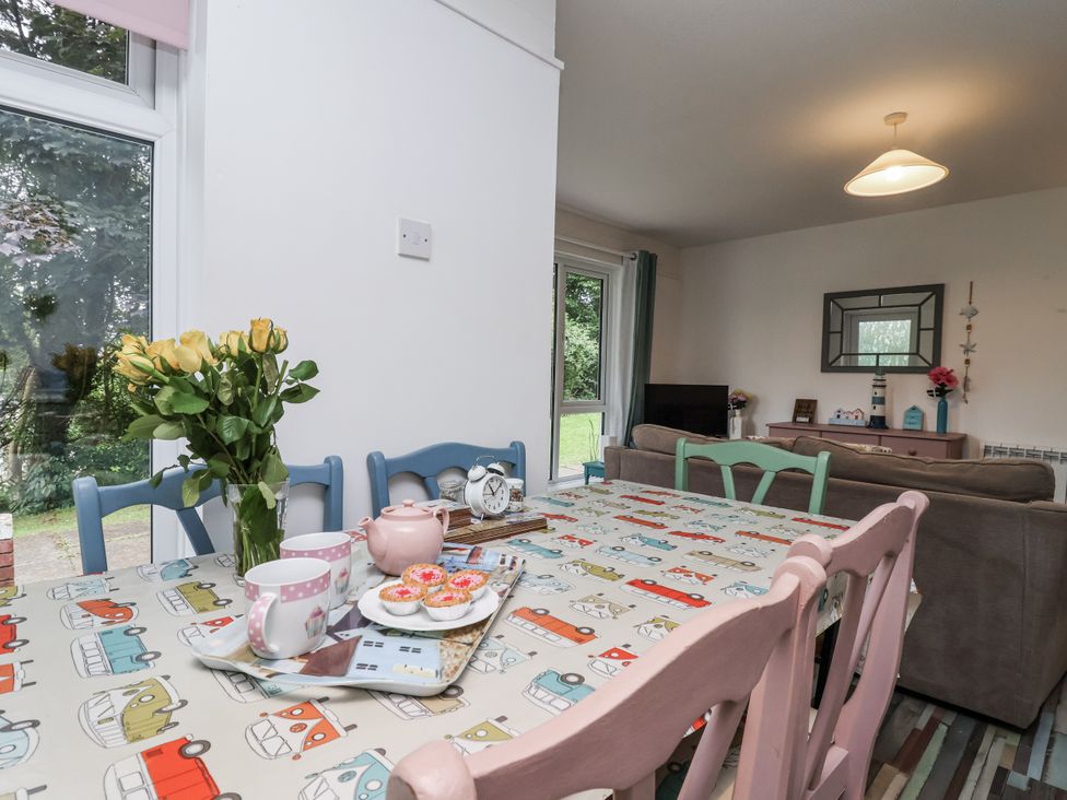A dining room with a table set with tea and flowers at Manorcombe 21 Honicombe Holiday Village near Gunnislake
