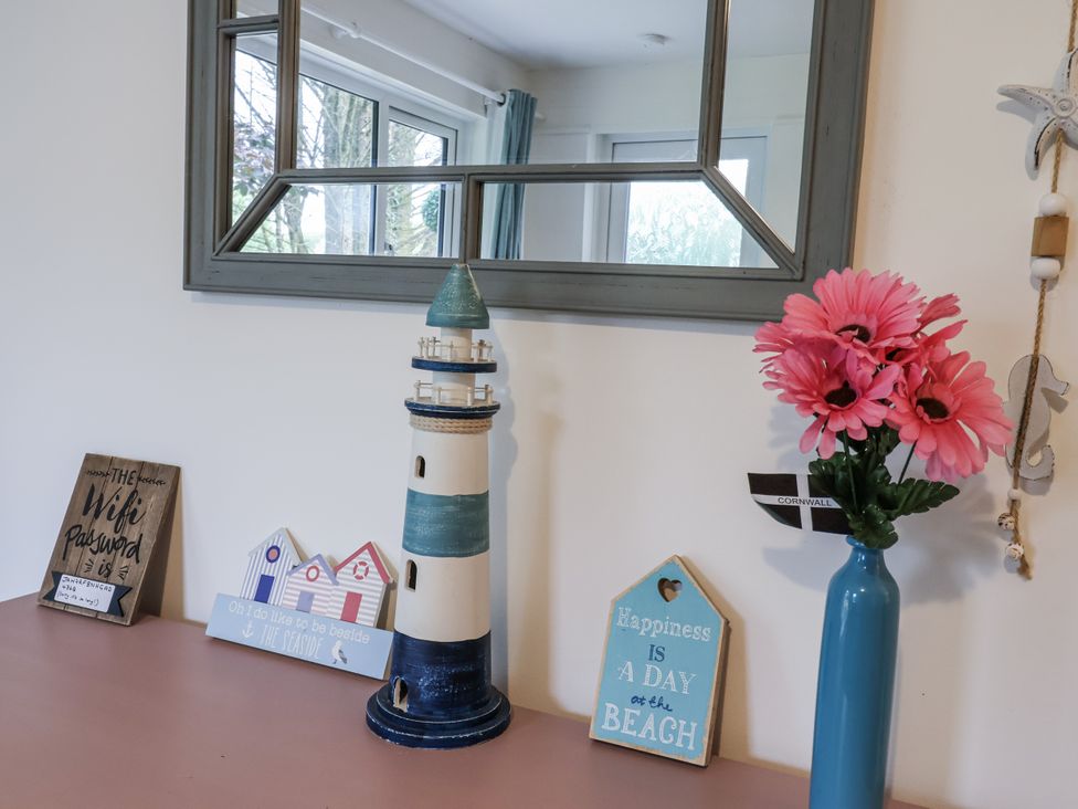 A decorative setup with a lighthouse, mirror, and flowers at Manorcombe 21 Honicombe Holiday Village near Gunnislake