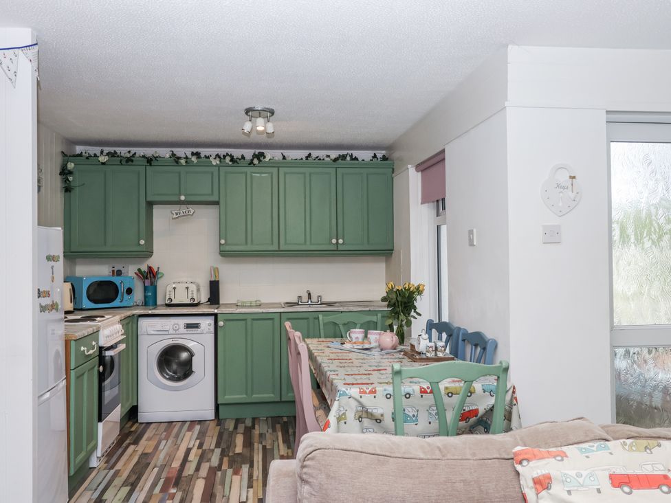 A kitchen with appliances and dining table at Manorcombe 21 Honicombe Holiday Village near Gunnislake