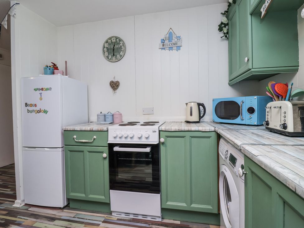 A kitchen with appliances including a refrigerator, oven and microwave at Manorcombe 21 in Honicombe Holiday Village near Gunnislake