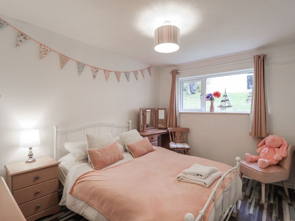 A bedroom with a bed and window at Manorcombe 21 in Honicombe Holiday Village near Gunnislake