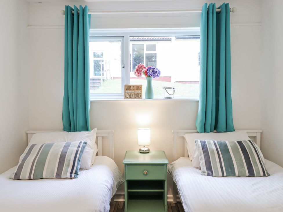 A bedroom with two beds and a window at Manorcombe 21 Honicombe Holiday Village near Gunnislake
