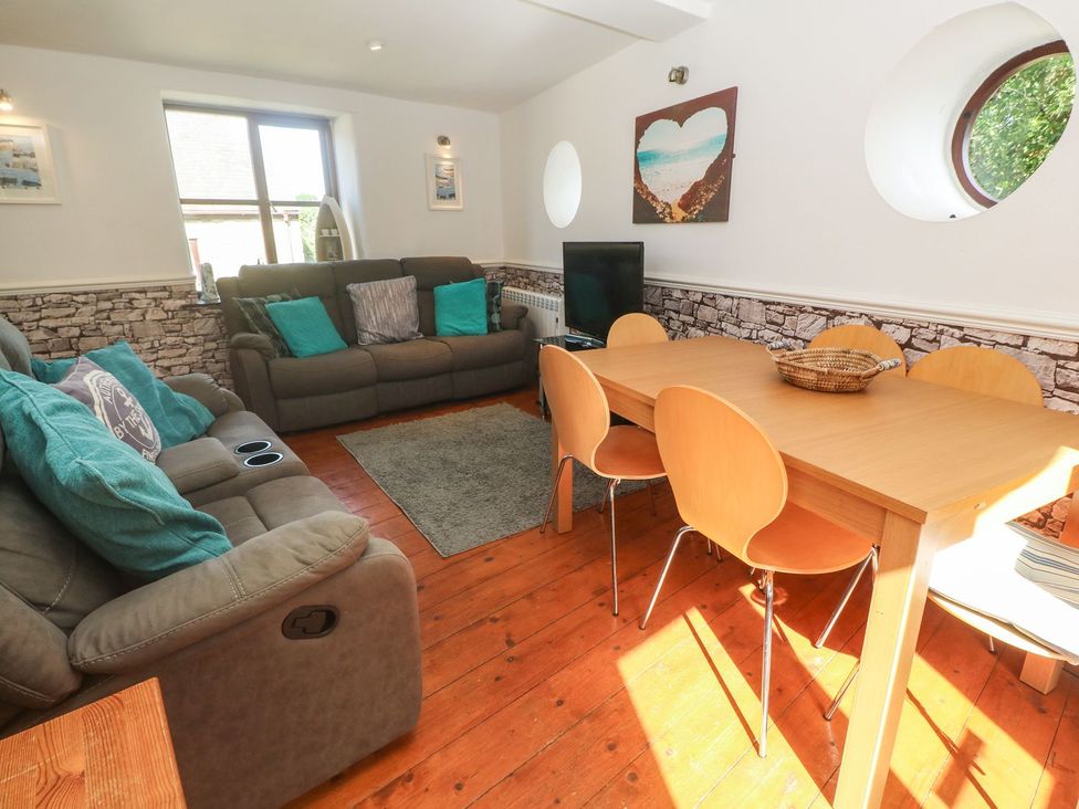 A living room with a sofa and dining table at Mill House Barn