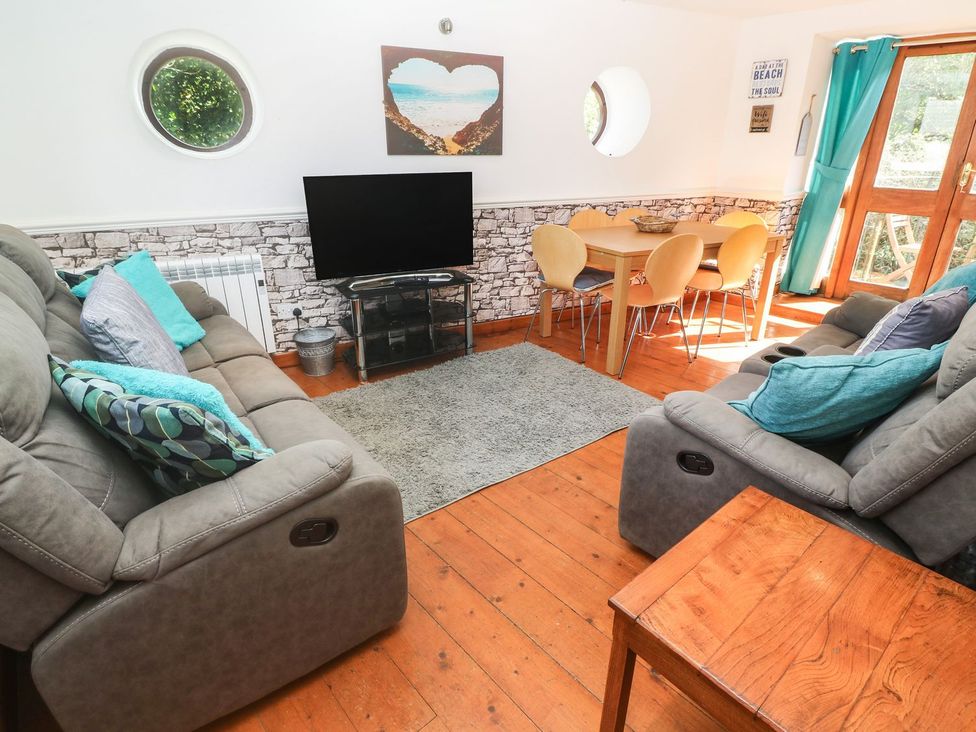 A living room with a sofa and dining area at Mill House Barn in 