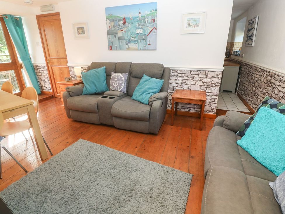 A living room with a sofa and dining table at Mill House Barn