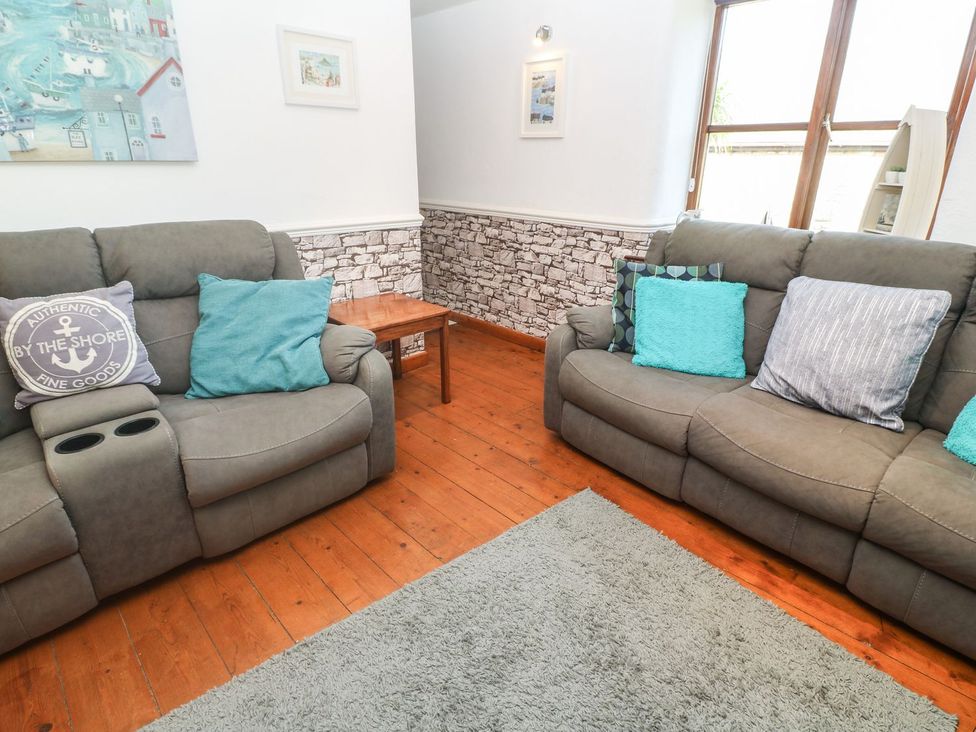 A living room with sofas and a table at Mill House Barn