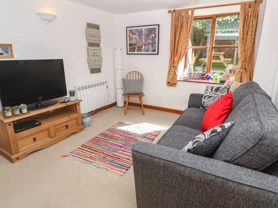 A living room with a sofa and television at Mill House Barn