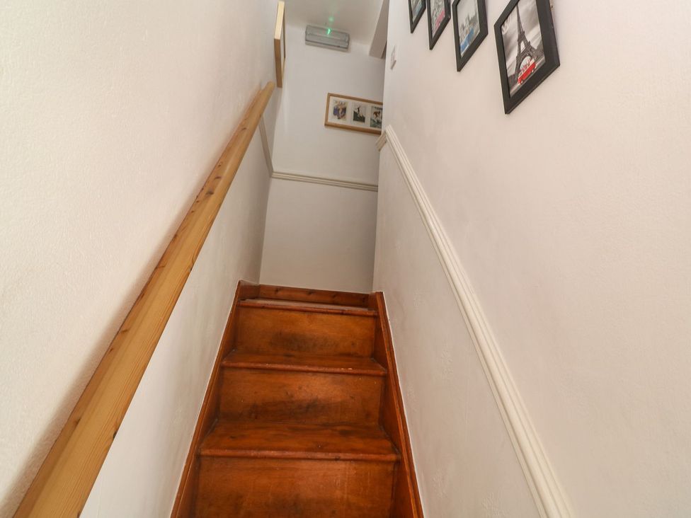 A staircase with wooden steps and wall pictures at Mill House Barn