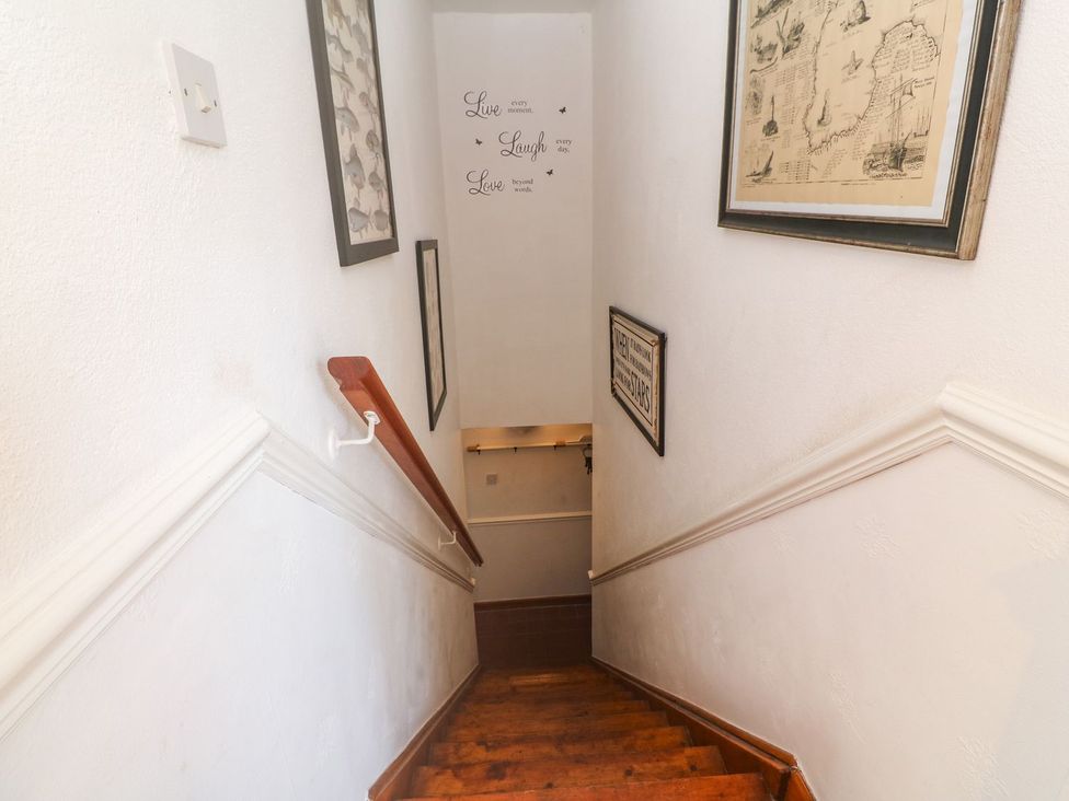 A staircase with wall art and a light switch at Mill House Barn
