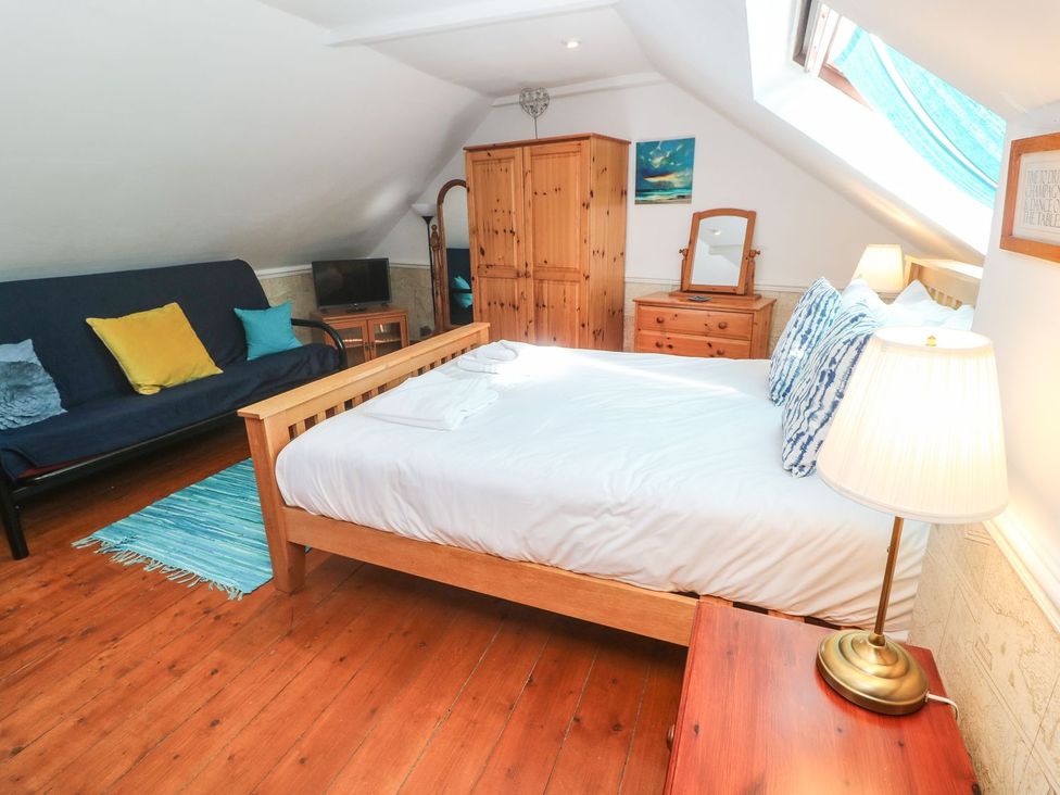 A bedroom with a bed and sofa bed at Mill House Barn 